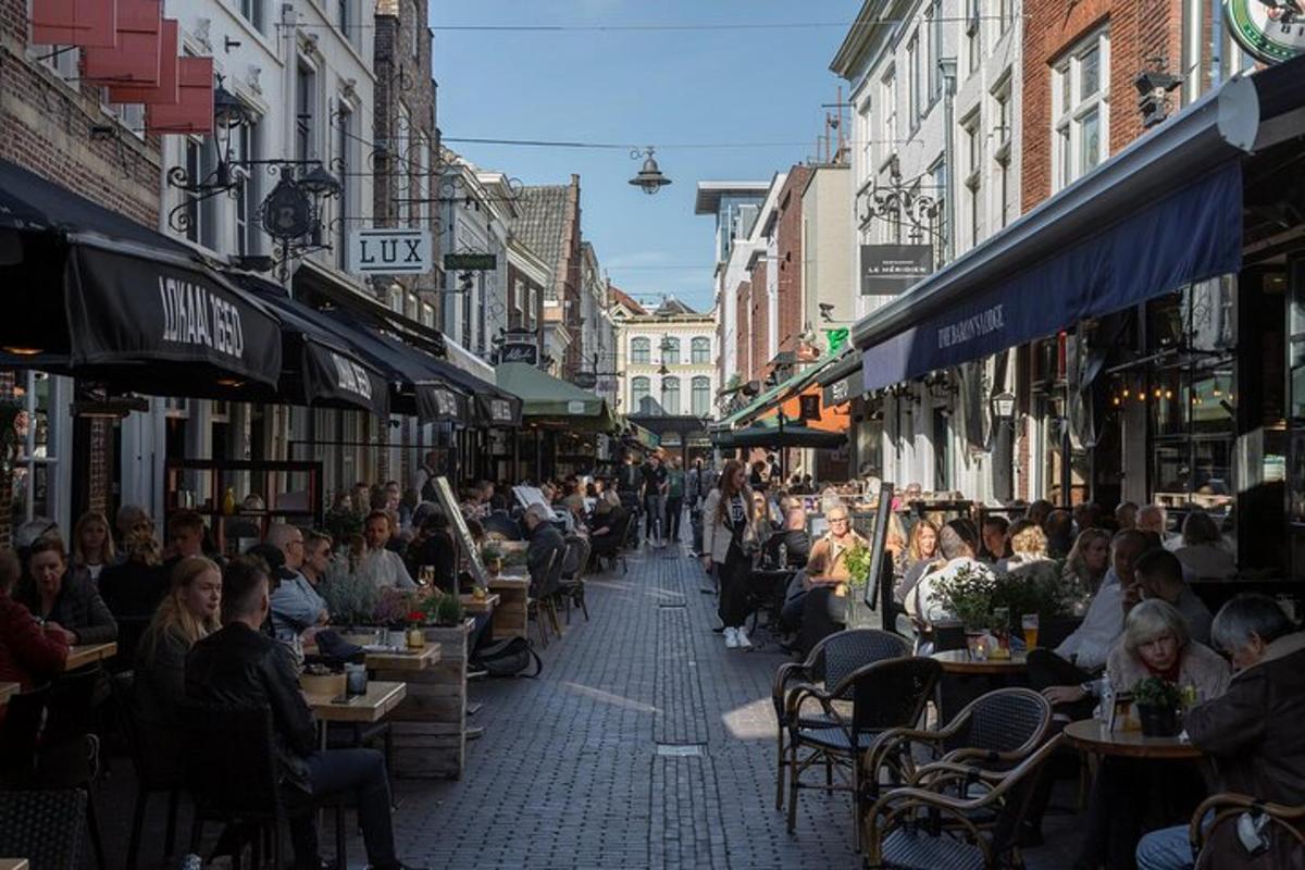 a crowd of people sitting at tables in a street
