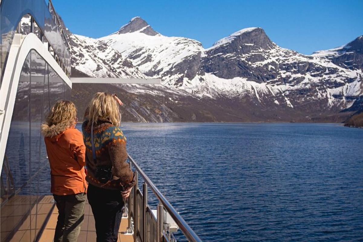 two women standing on a cruise ship looking at the mountains
