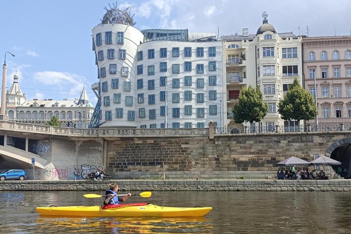 un ragazzo in un kayak giallo in un fiume con edifici