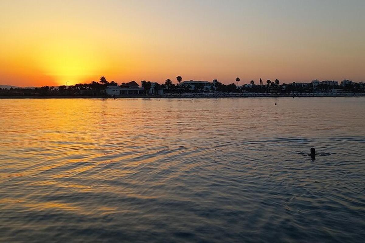 a person swimming in the water at sunset