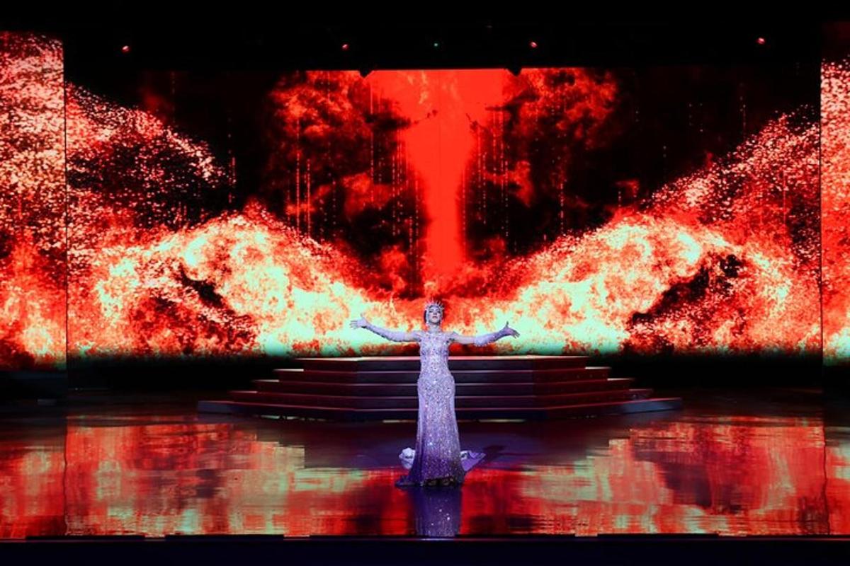 a painting of a cross on a stage with flames
