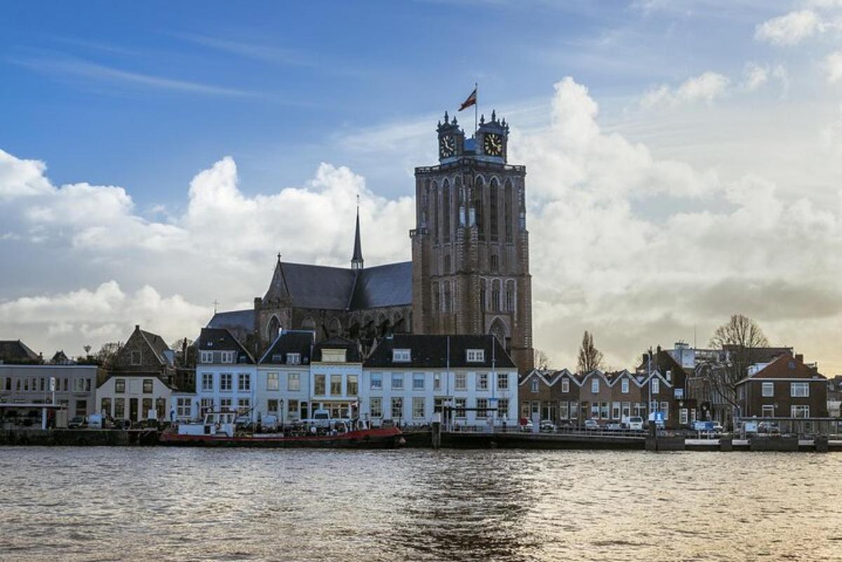 un edificio con una torre dell'orologio accanto a uno specchio d'acqua
