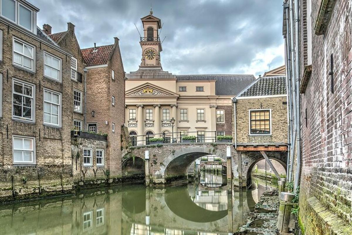 a building with a clock tower and a bridge over a river