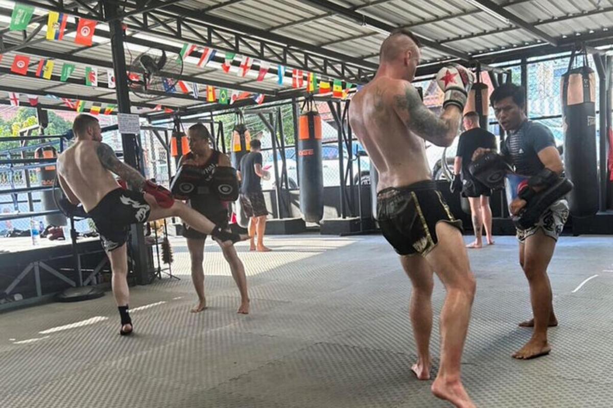sekumpulan lelaki berdiri di gimnasium dengan peralatan tinju