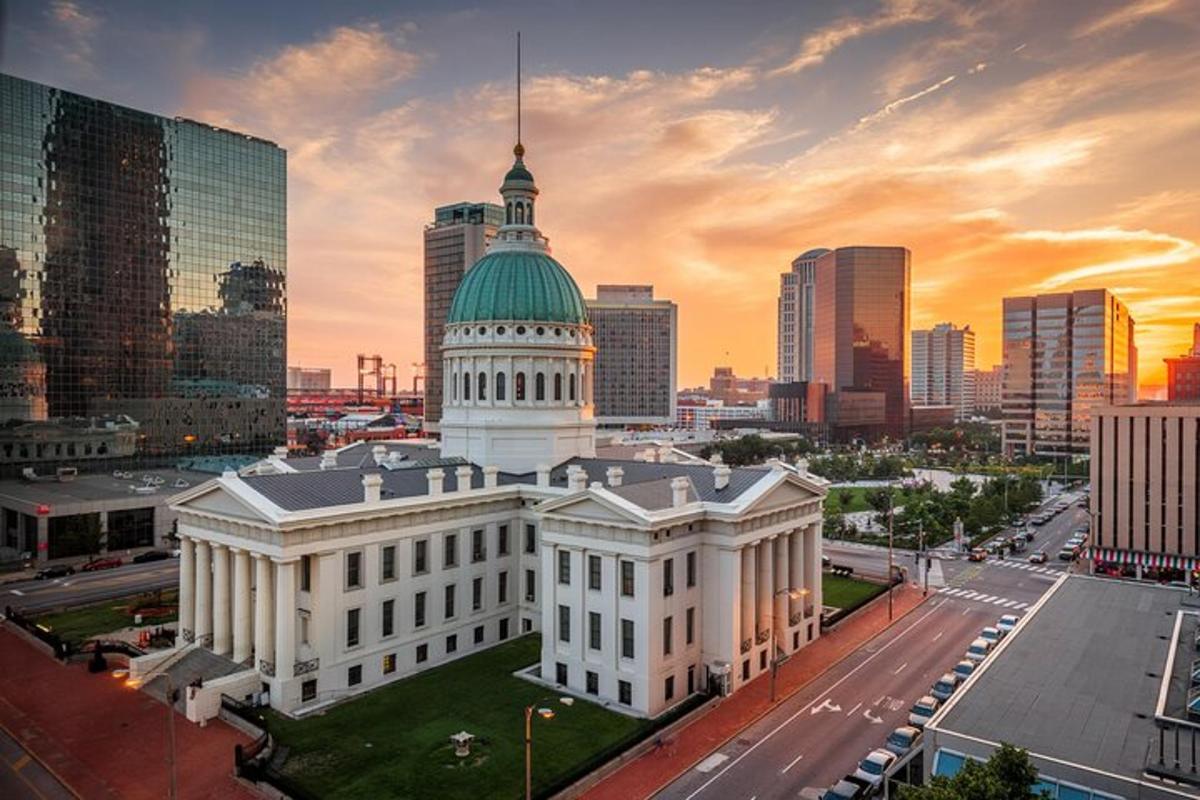 a large white building with a green dome in a city
