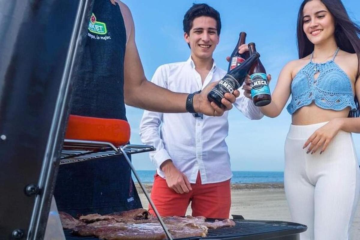 un uomo e una donna in piedi sulla spiaggia con in mano una birra