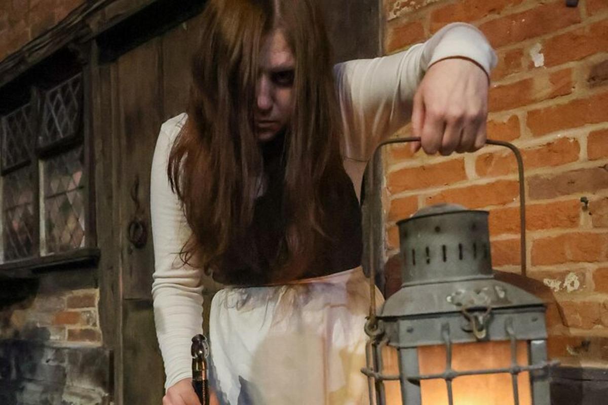 Žena stojí vedle kovové lucerny