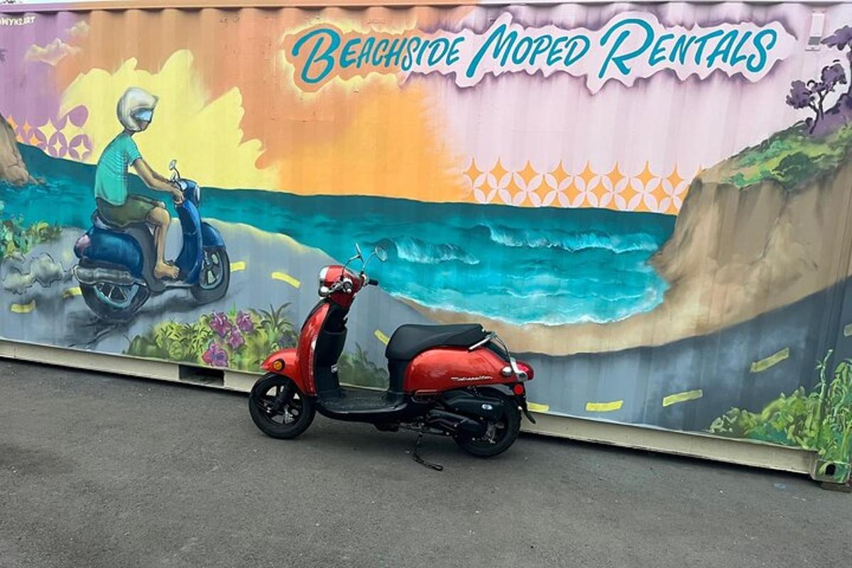 un escúter vermell aparcat davant d'un mural