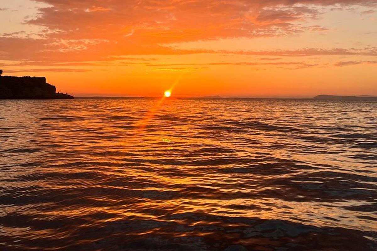 un tramonto sull'oceano con il sole che tramonta