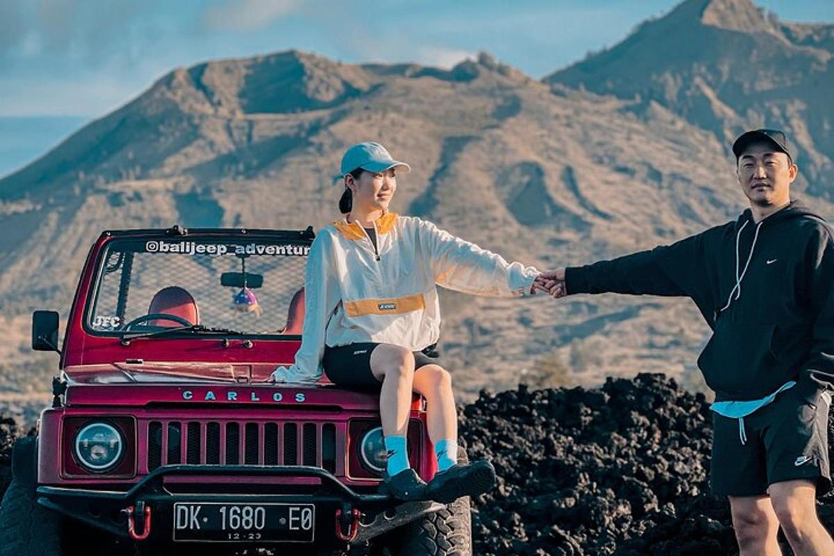 un homme et une femme assis sur le toit d'une jeep