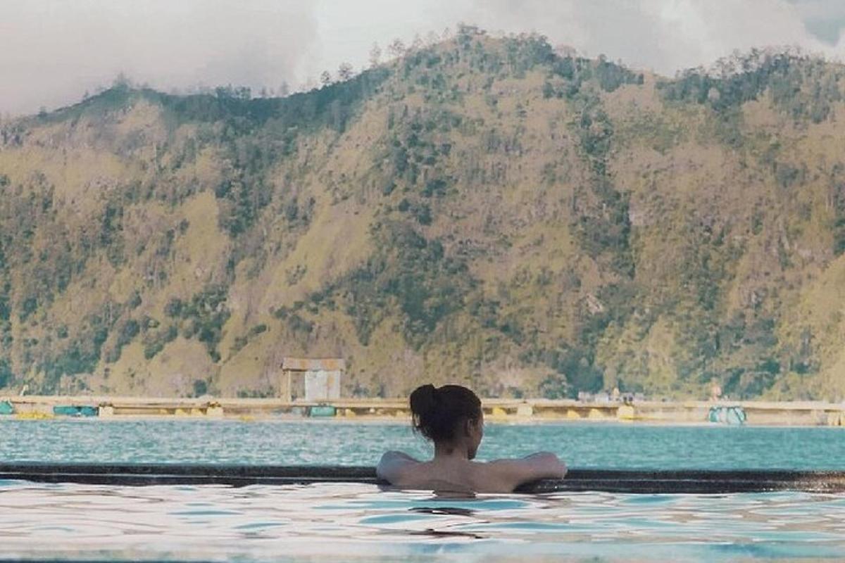 une femme dans une piscine avec une montagne en arrière-plan