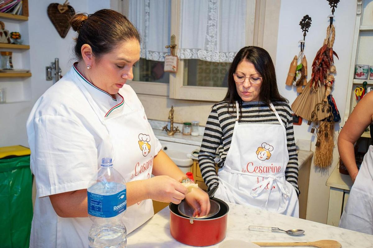 dve ženski v kuhinji pripravljata hrano v loncu