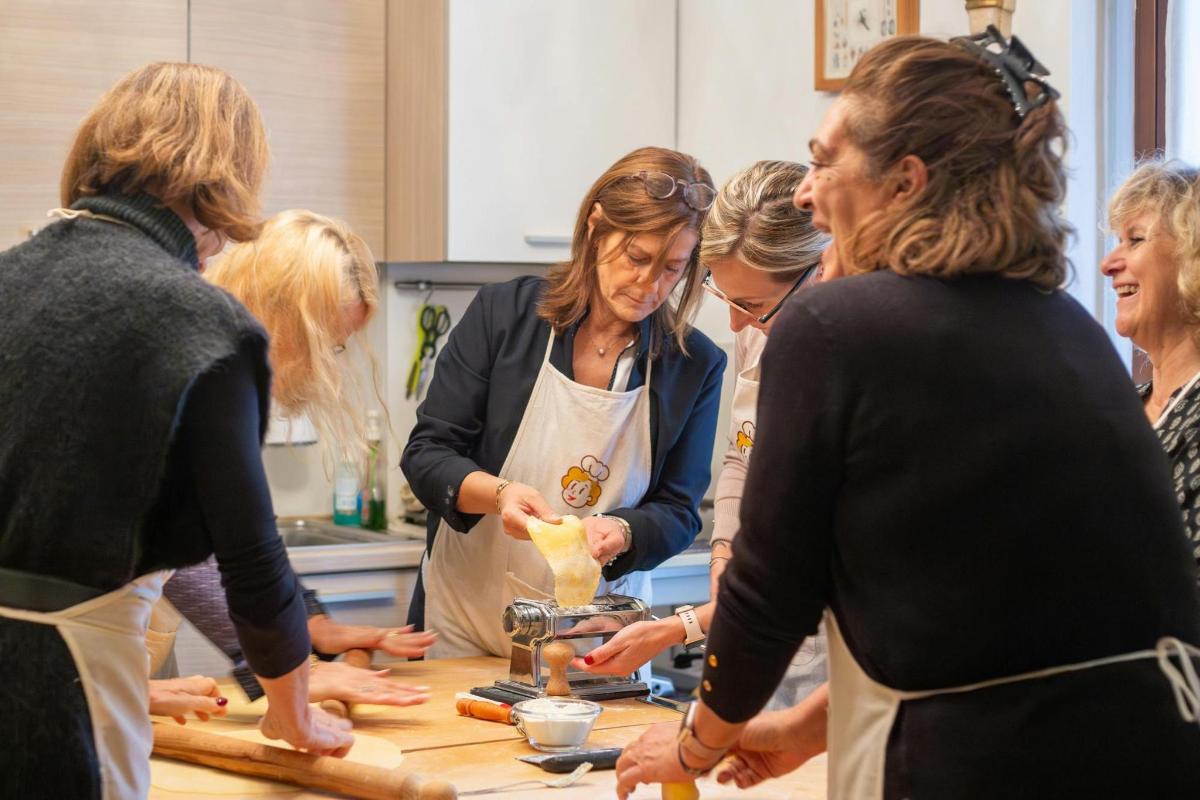 een groep vrouwen die rond een toonbank staan en eten bereiden