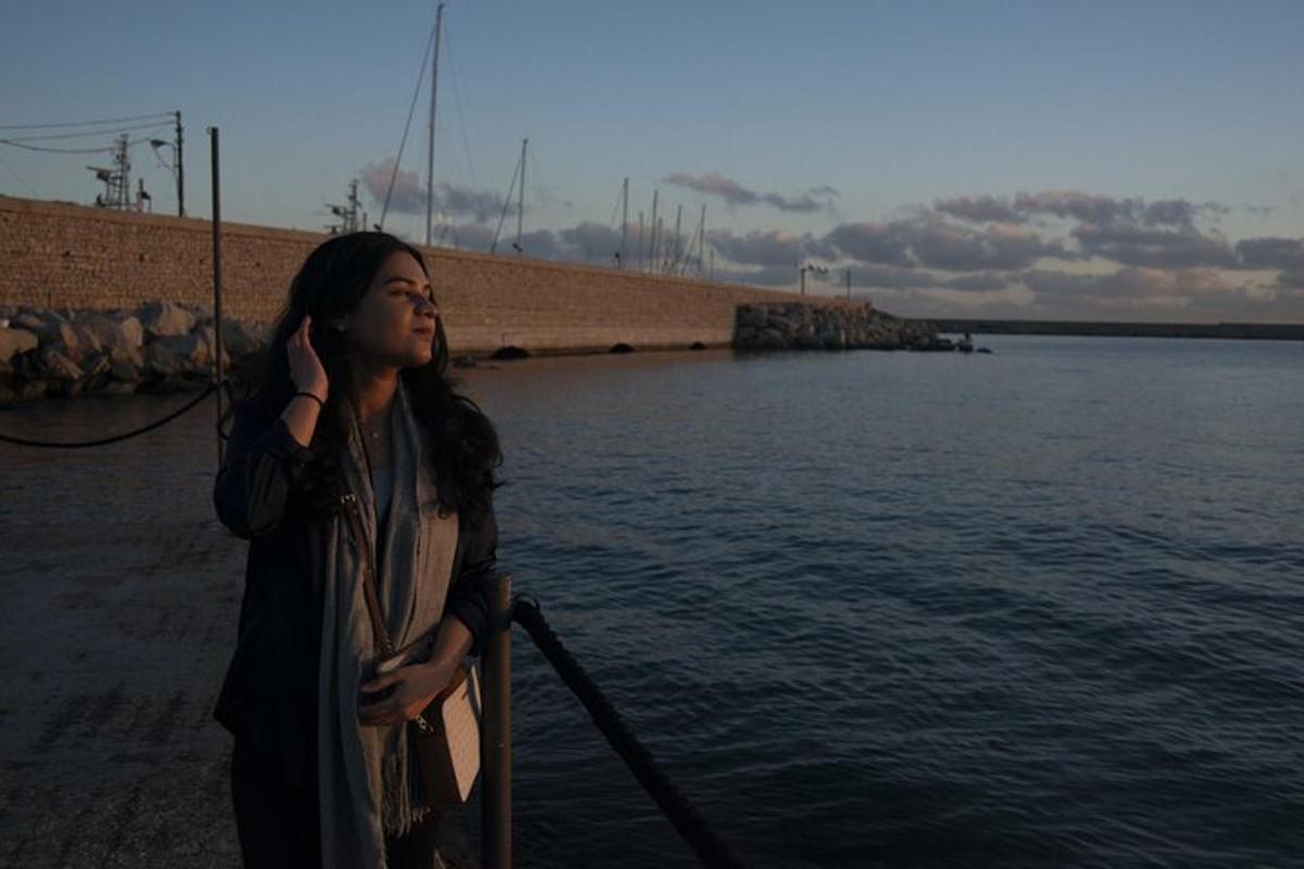 kona að tala í farsíma við vatnið