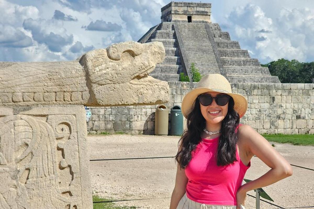 a woman wearing a straw hat standing in front of a pyramid