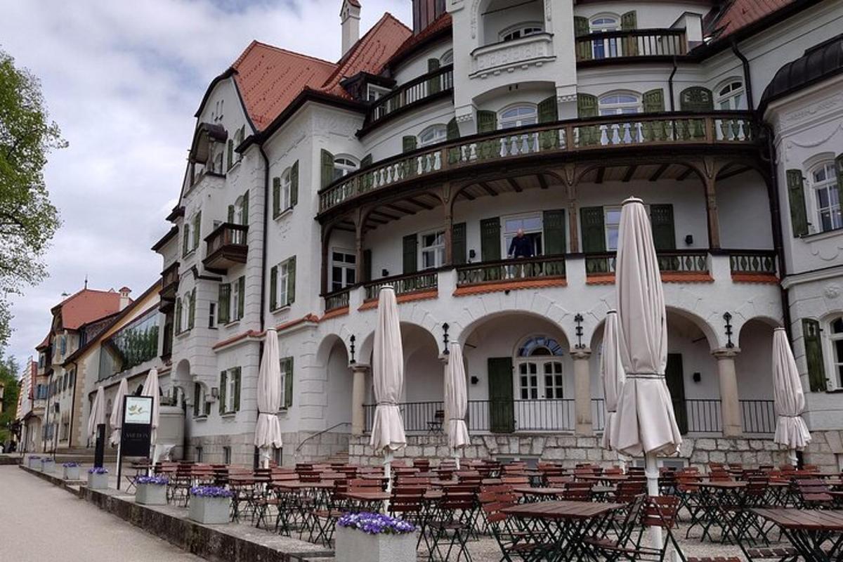 ein Gebäude mit Tischen und Sonnenschirmen davor