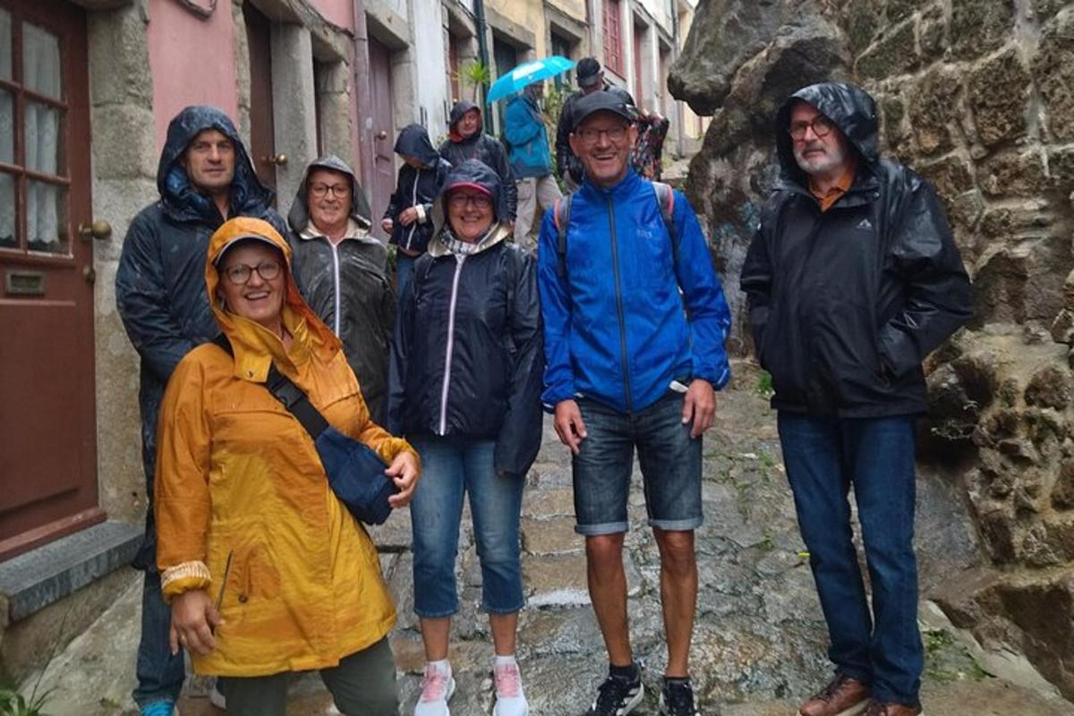 skupina lidí pózujících pro fotografii v dešti