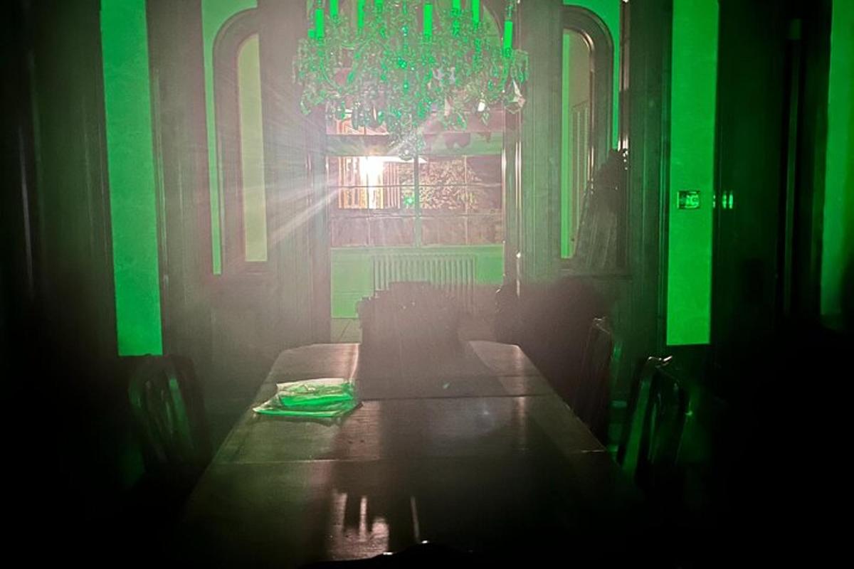 a green room with a table and a chandelier