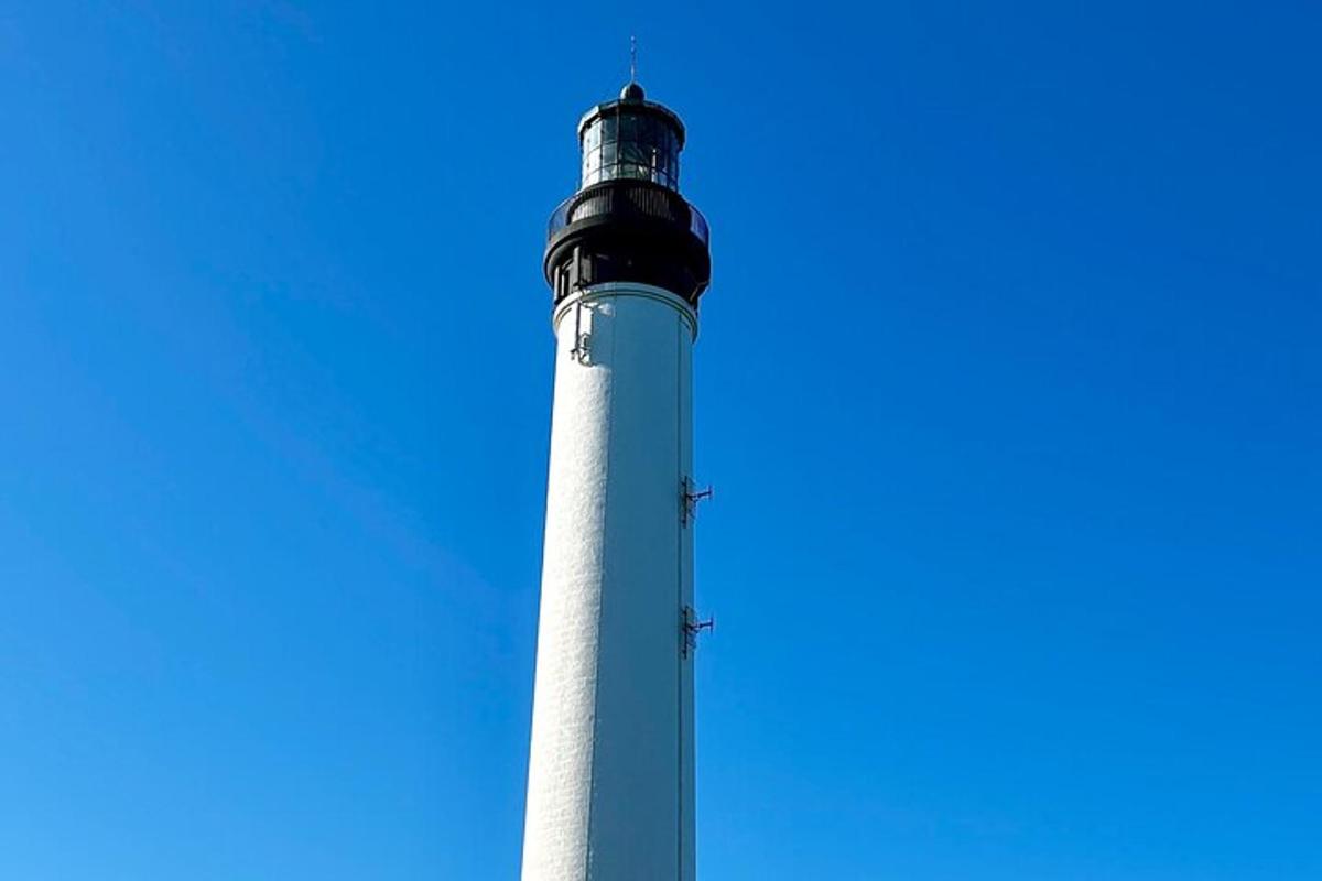 Un faro alto con un cielo azul al fondo