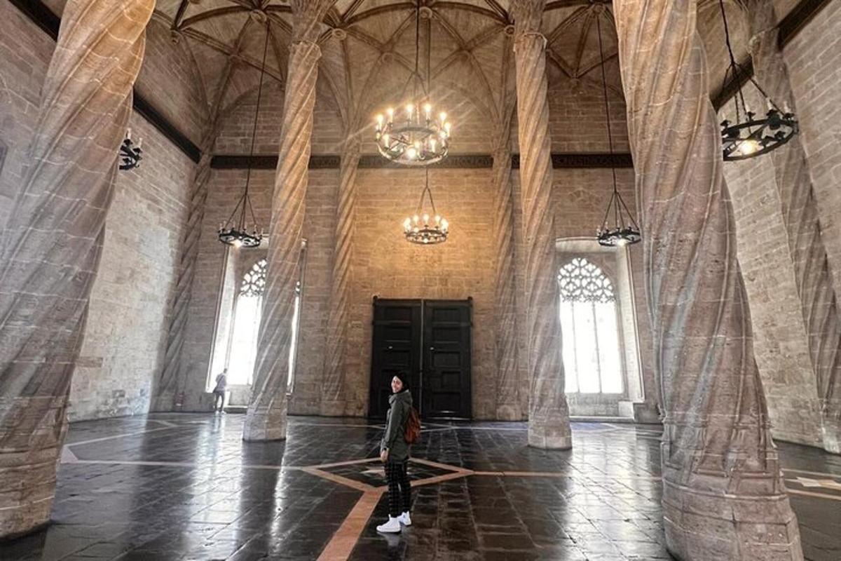 uma pessoa caminhando em uma grande sala com colunas