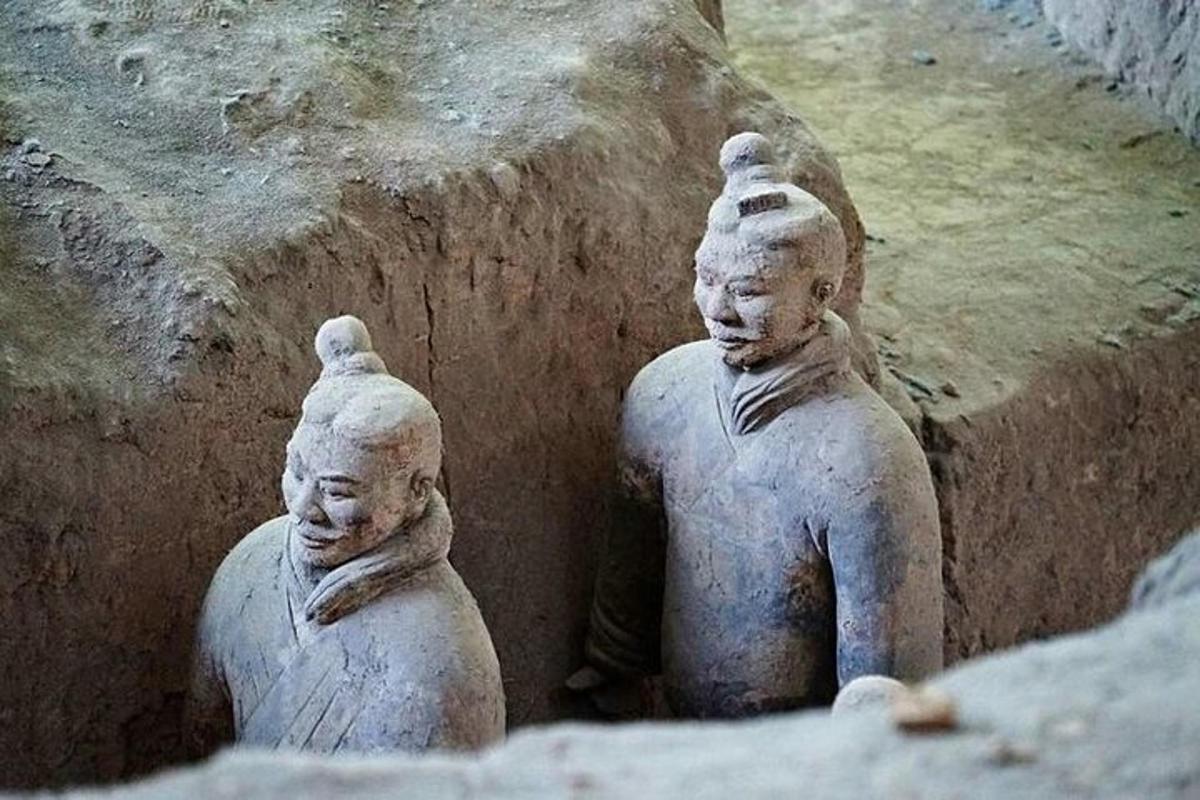 two stone statues are sitting in a cave