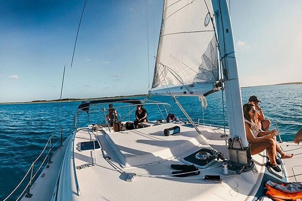eine Gruppe von Menschen sitzt auf einem Segelboot im Wasser