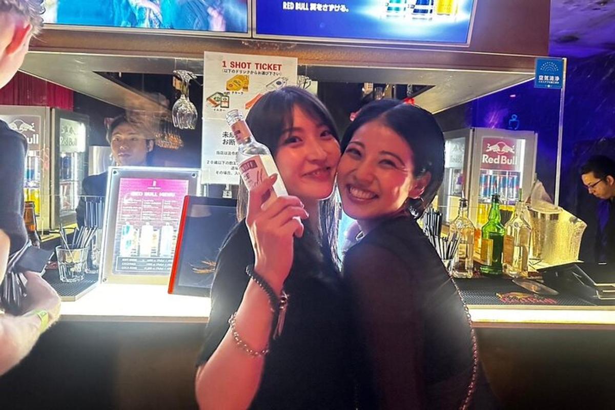 two women standing next to each other holding a cell phone