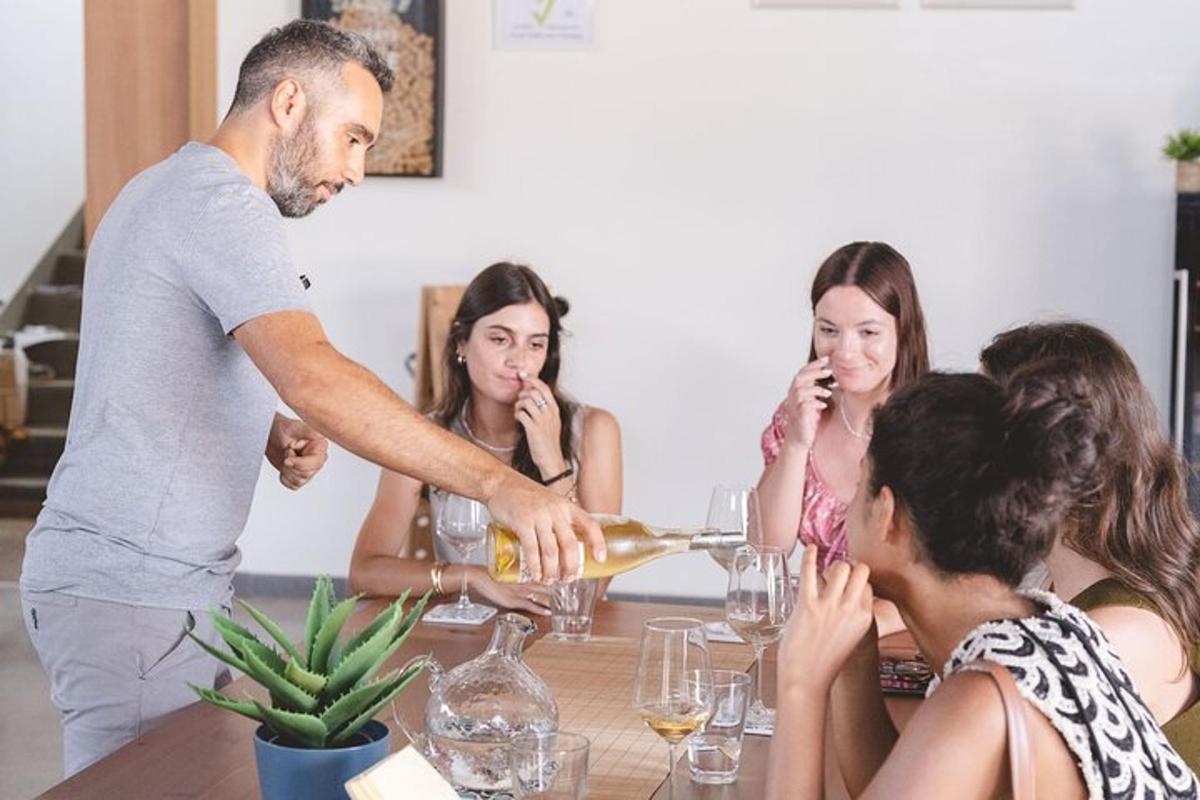 Ένας άντρας σερβίρει κρασί σε μια ομάδα ανθρώπων σε ένα τραπέζι