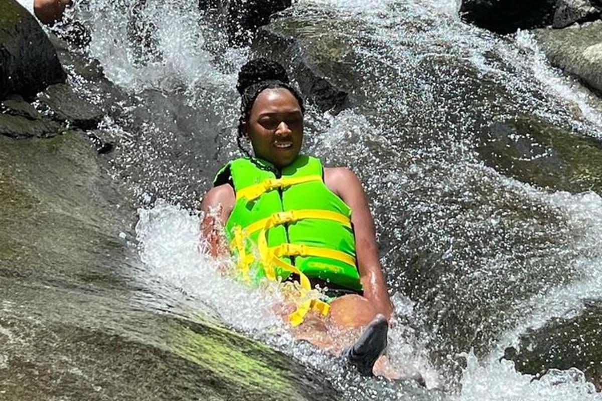 Un hombre con chaleco salvavidas en una cascada.