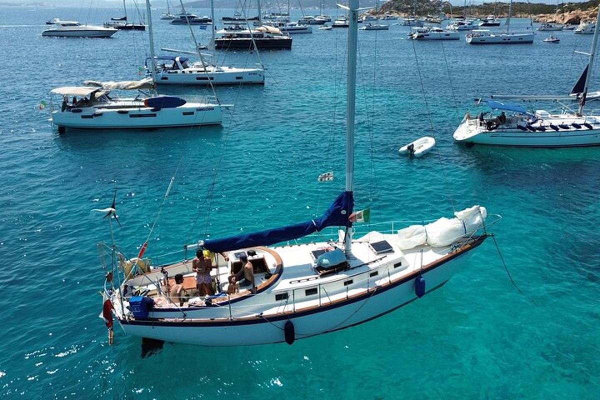 una barca a vela in acqua con altre barche