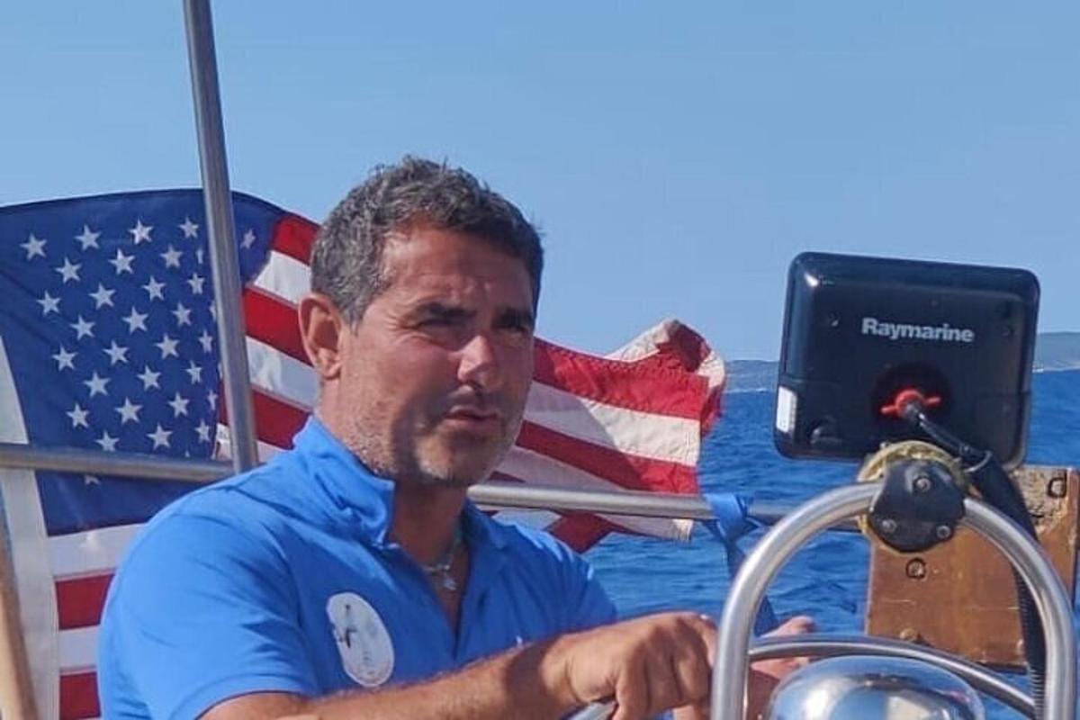 un uomo seduto su una barca con una bandiera americana