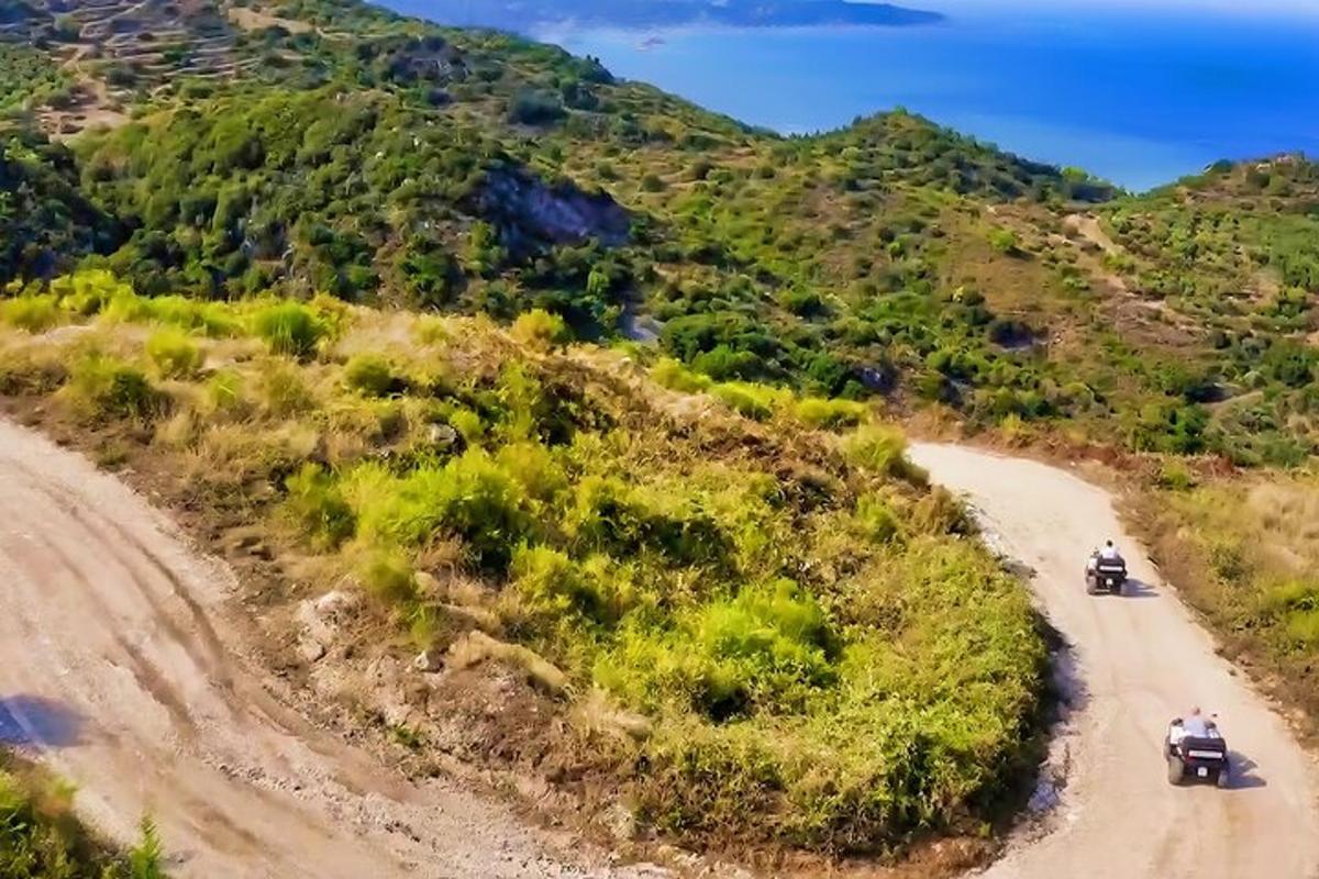 duas pessoas andando de motocicleta em uma estrada de terra