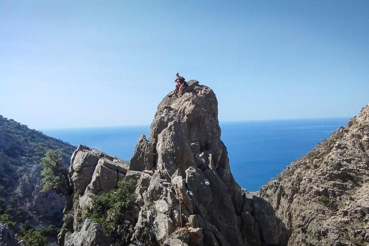 una persona asseguda al cim d'una muntanya