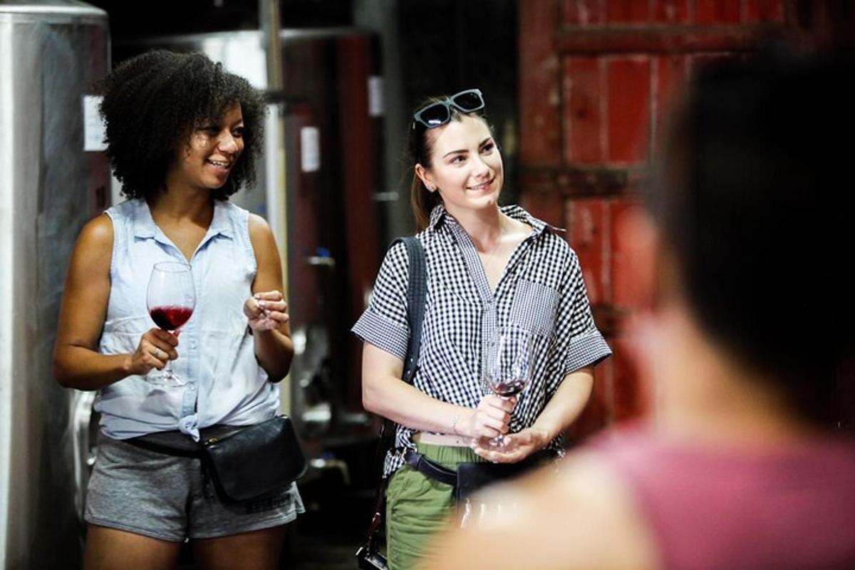 twee vrouwen lopen over straat met glazen wijn in hun handen