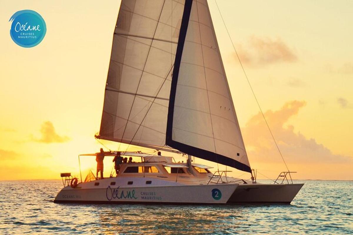 a sailboat on the water with a sunset in the background
