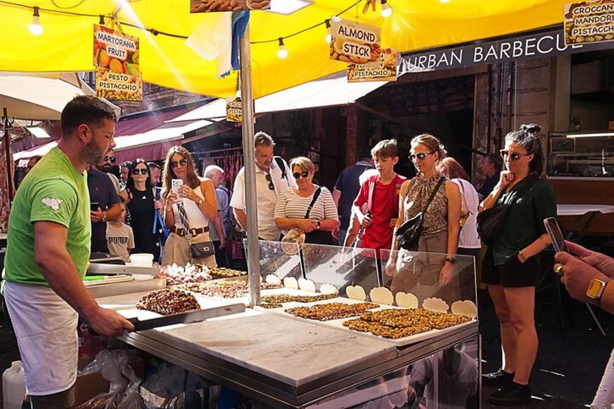 a group of people standing around a food stand at a market