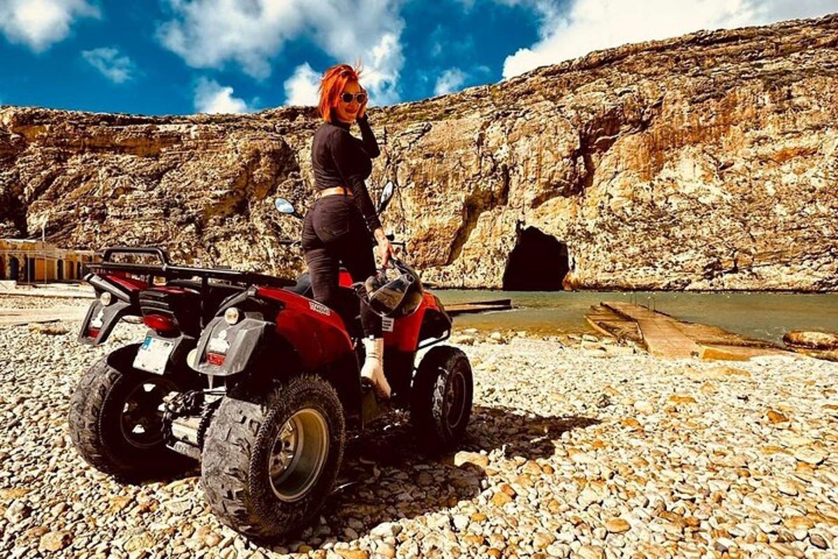 a woman standing next to a atv on a rocky beach