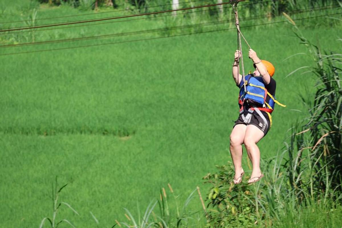 a person hanging on a rope on a zip line