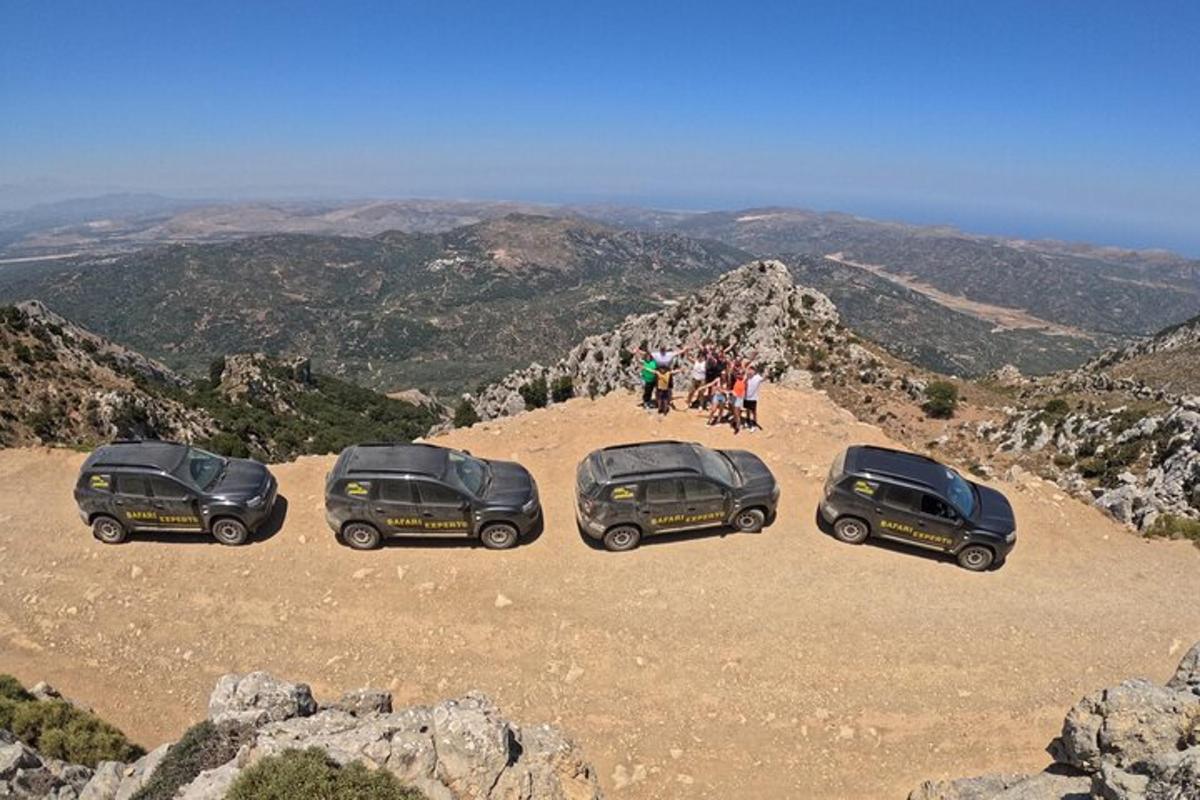um grupo de três carros estacionados no topo de uma montanha