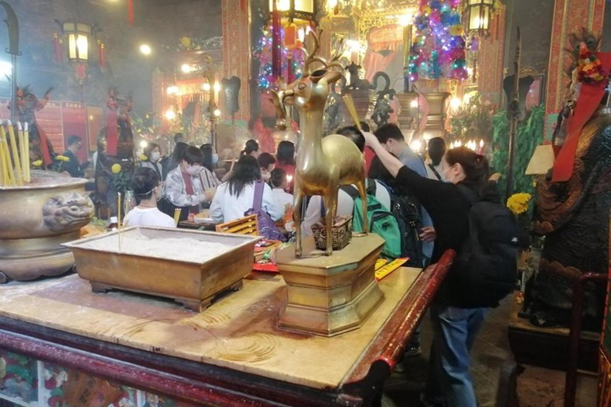 um grupo de pessoas em um templo com uma estátua de ouro