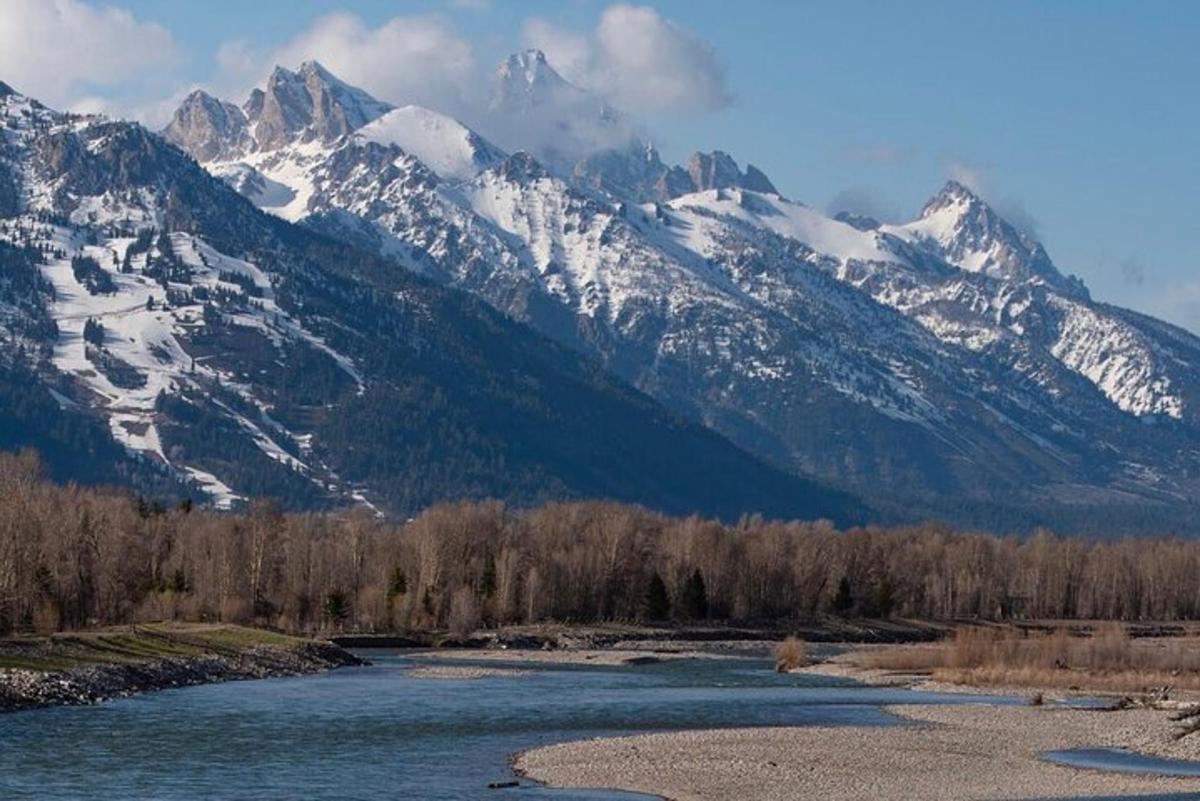 a river with snow capped mountains in the background