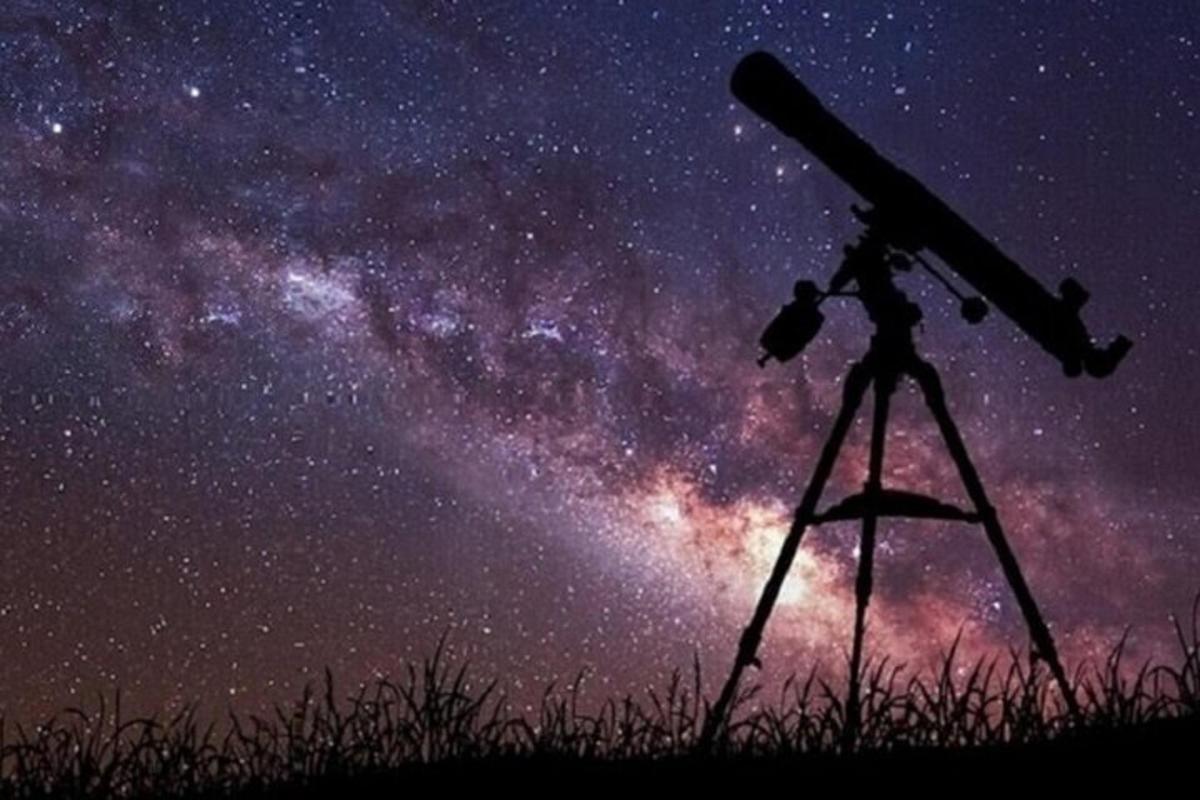 un telescop pe un trepied care privește Calea Lactee