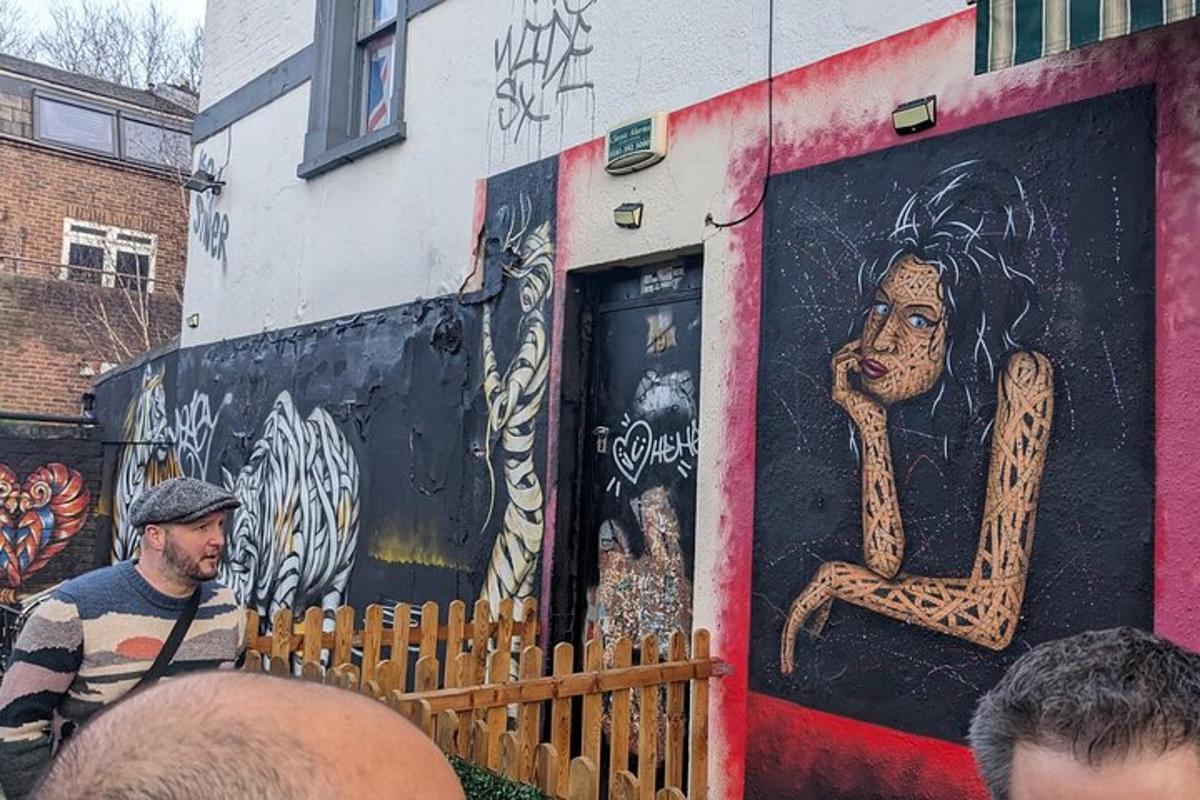 un home dret davant d'un edifici amb un mural