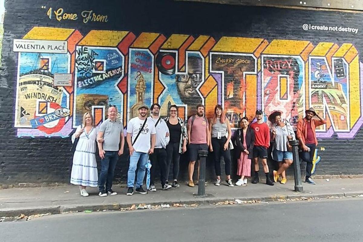 sekumpulan orang berdiri di hadapan mural