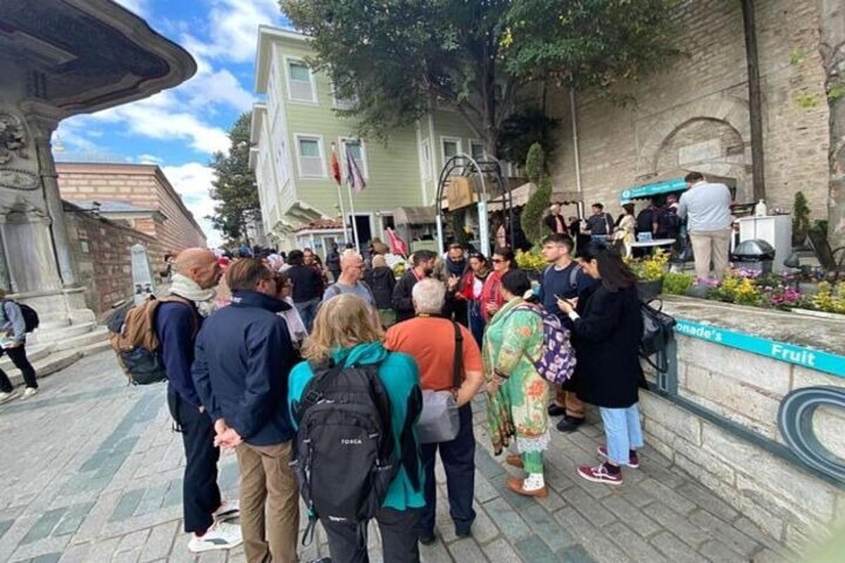 hópur fólks stendur fyrir utan byggingu