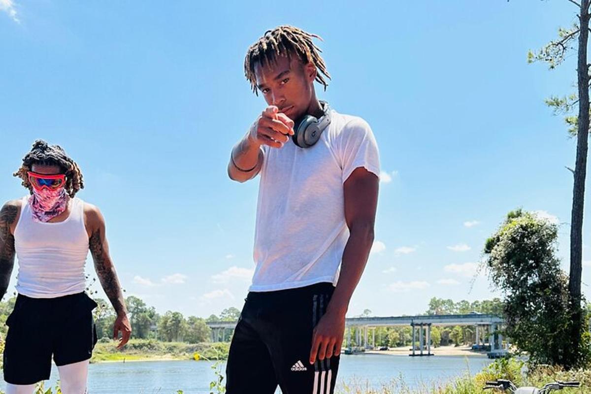 two young men standing next to a body of water