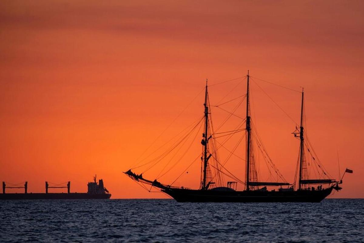 un veler a l'oceà a la posta de sol