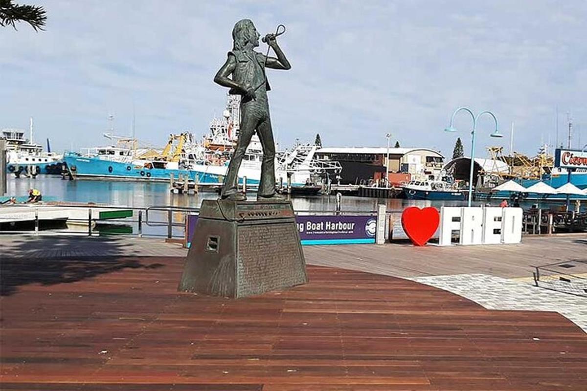 a statue of a man playing a trumpet in a marina