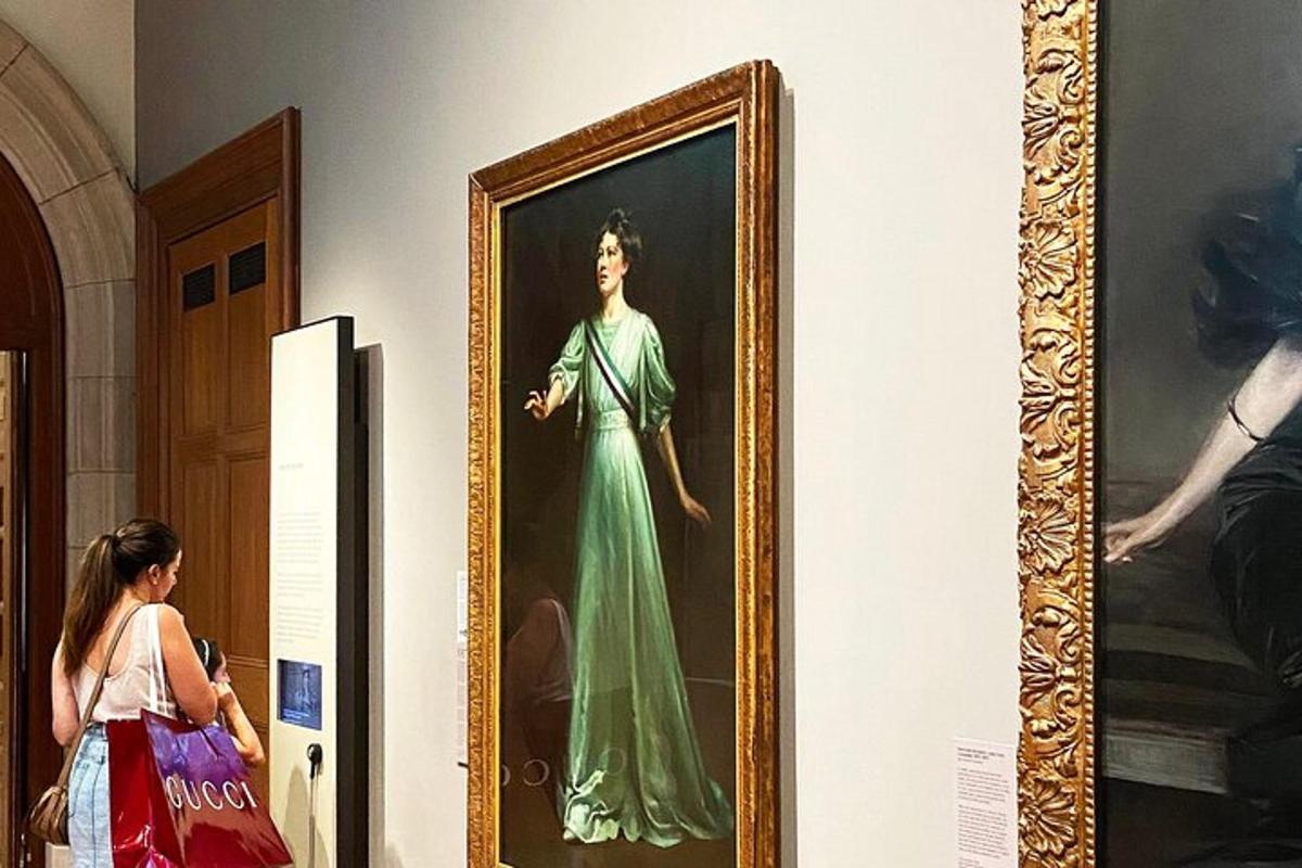 μια γυναίκα κοιτάζει έναν πίνακα που απεικονίζει μια γυναίκα με πράσινο φόρεμα
