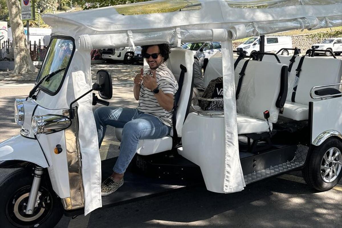 muž sediaci v golfovom vozíku a pozerajúci sa do mobilného telefónu